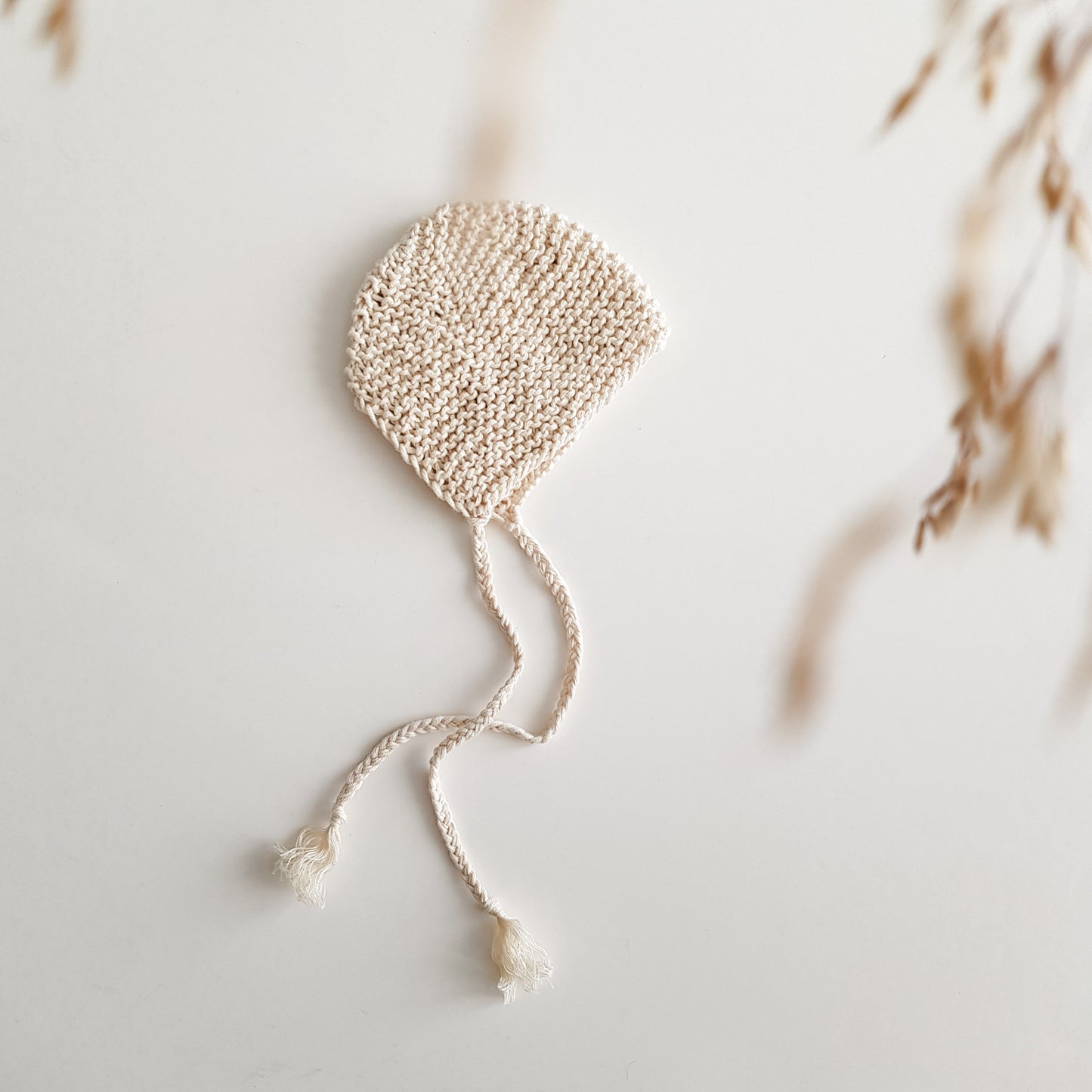 Knitted bonnet for baby doll, natural white